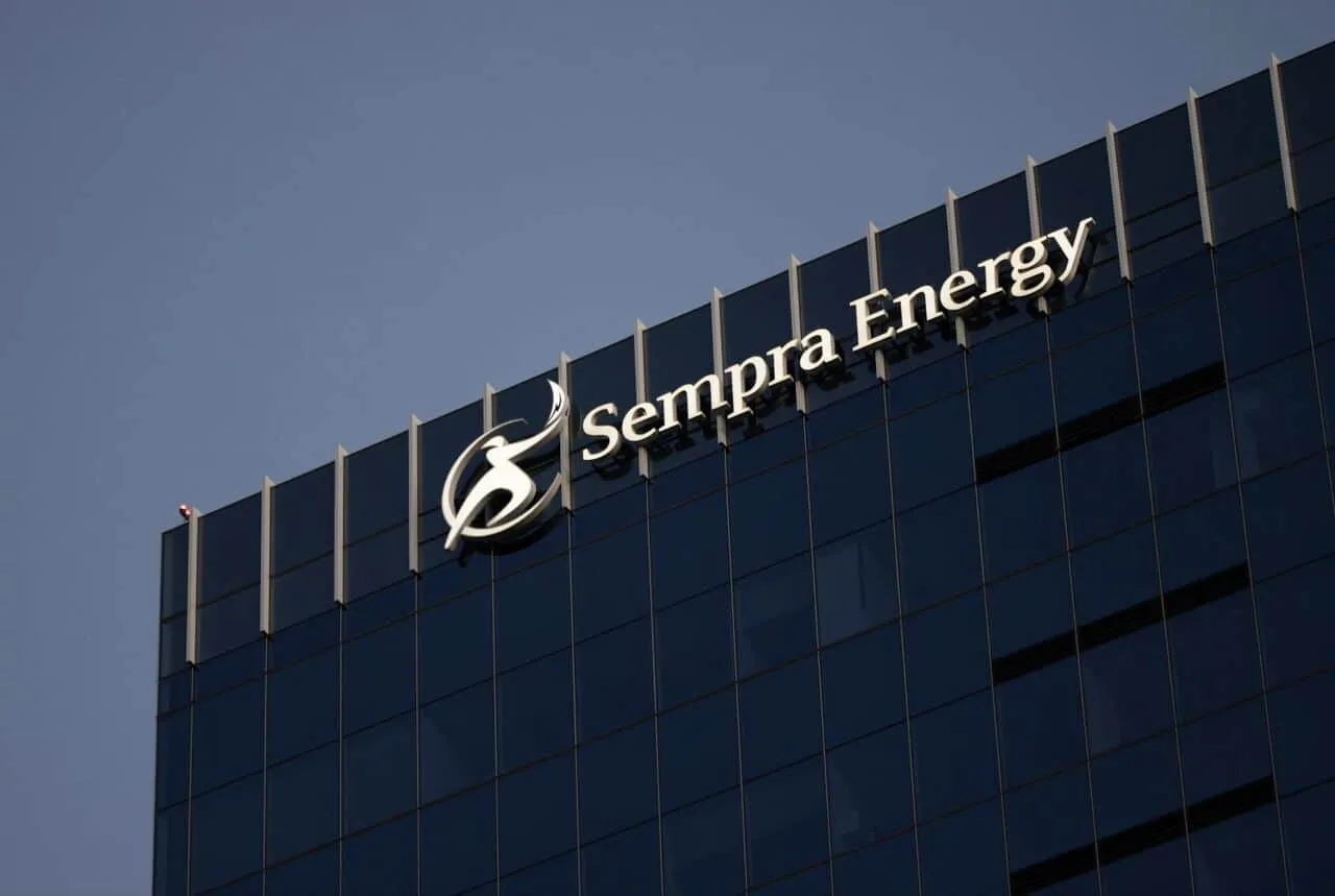 Sempra Energy logo on a glass office building facade against a blue sky.