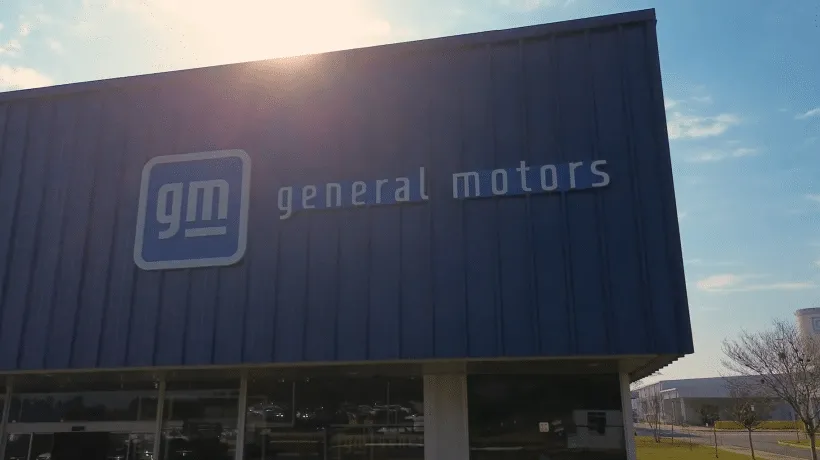 General Motors building exterior with blue siding and the GM logo on the facade