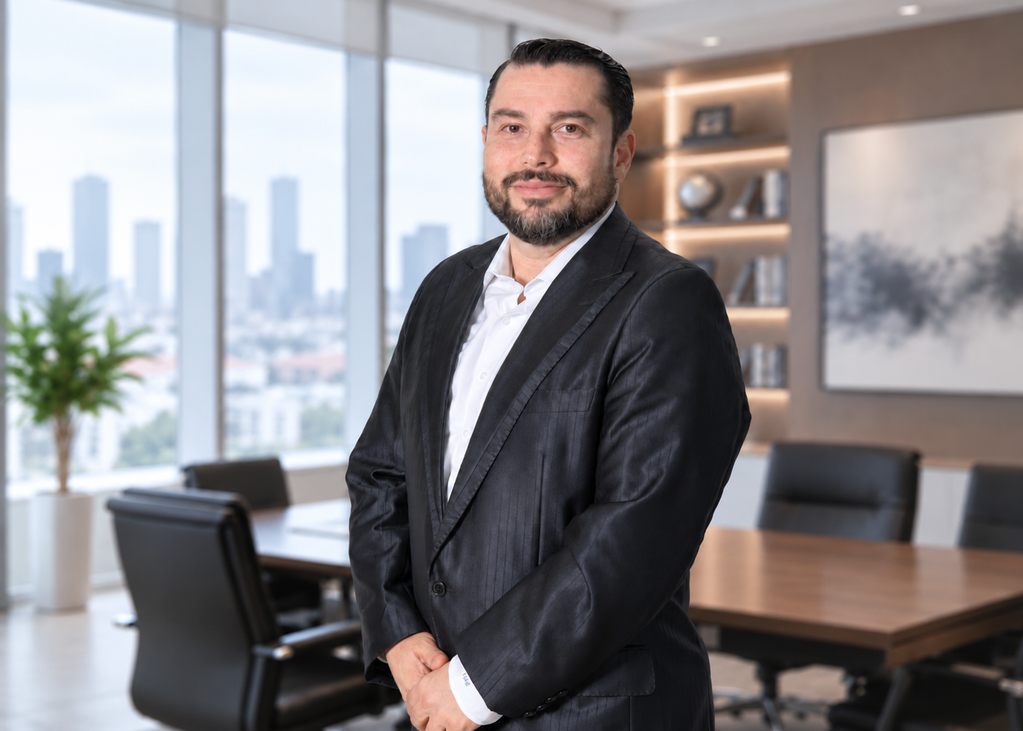 26-09-08 Ricardo de la Garza- México Globaim - Petróleo y Energía Professional man in a dark suit standing in a modern office, with a city skyline visible through large windows behind him