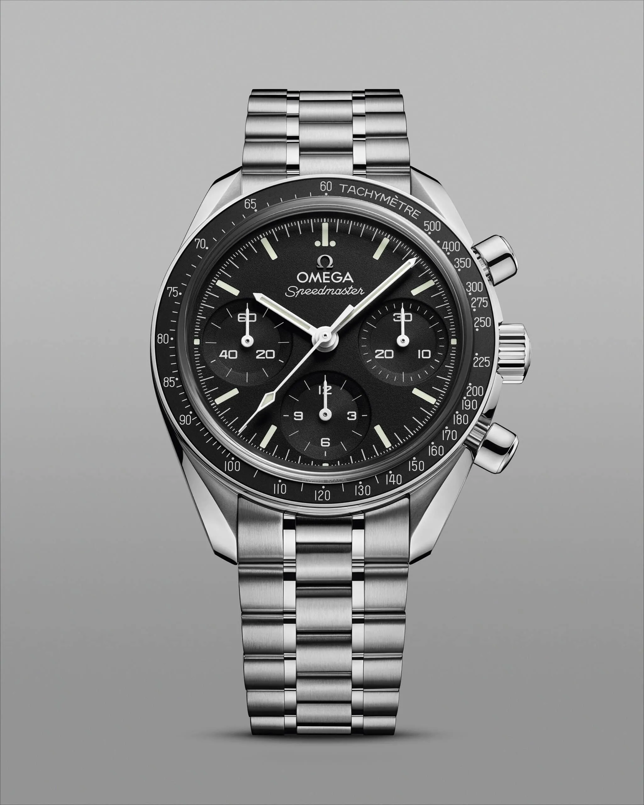 Close-up of an Omega Speedmaster stainless steel watch with a black dial, three subdials, and a tachymeter bezel.