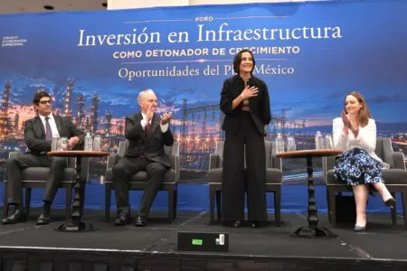 Panel discussion on infrastructure investment with four speakers on a stage and a blue backdrop behind them (text reads 'Inversión en Infraestructura').