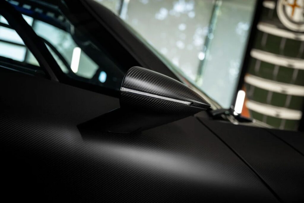 Picture10 - Petróleo y Energía Close-up of a carbon-fiber side mirror housing on a black sports car...