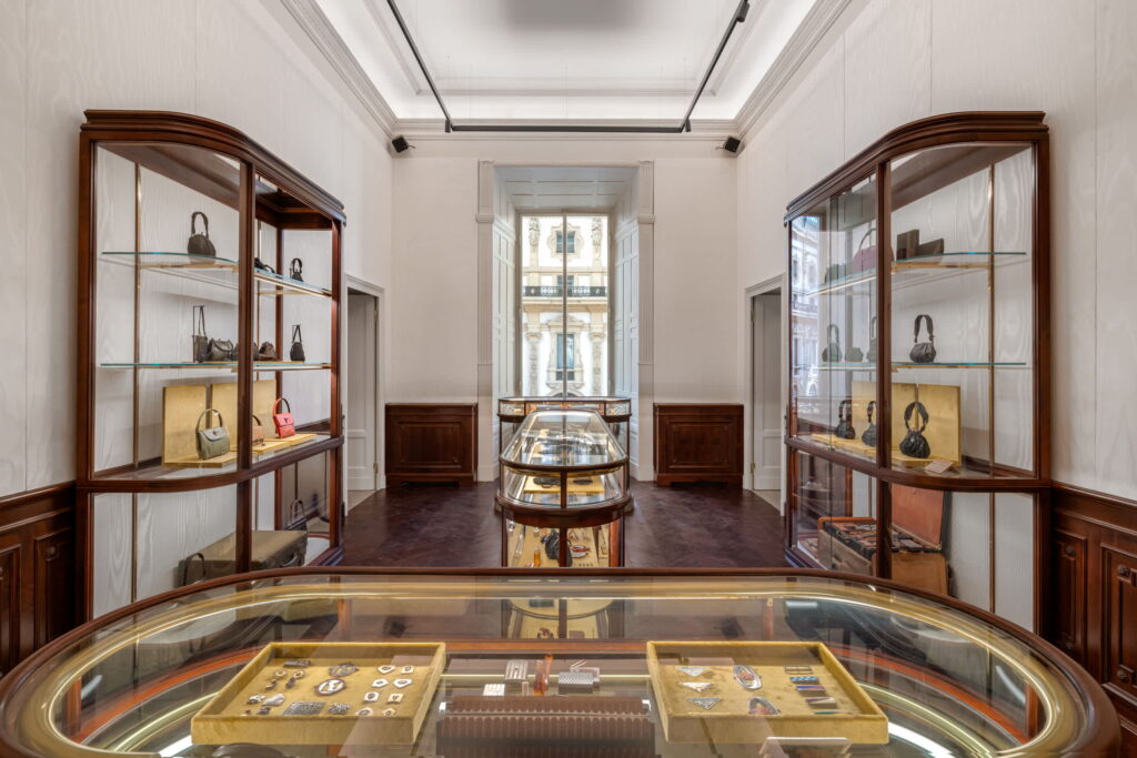 Pradasphere_Prada Galleria Vittorio Emanuele II_01 - Petróleo y Energía Elegant jewelry gallery interior with glass display cases along the walls and a curved central display case.