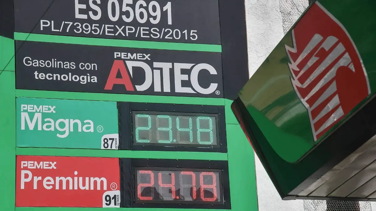 Gasoline price board at Pemex station showing Magna and Premium prices, with AdTec logo and green branding.