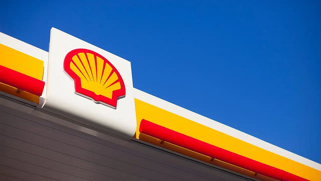 Shell logo on a white canopy with red and yellow accents against a clear blue sky.