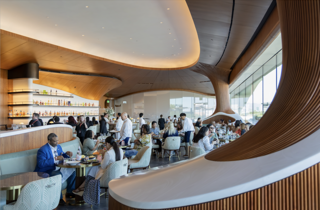 museo lucas 2026-09-23 a las 94927 am - Petróleo y Energía Busy upscale restaurant with curved wooden interior and diners at tables under warm lighting
