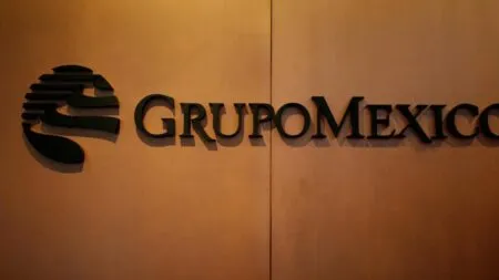 Grupo Mexico company sign in dark letters on a tan wall with a left-hand abstract logo
