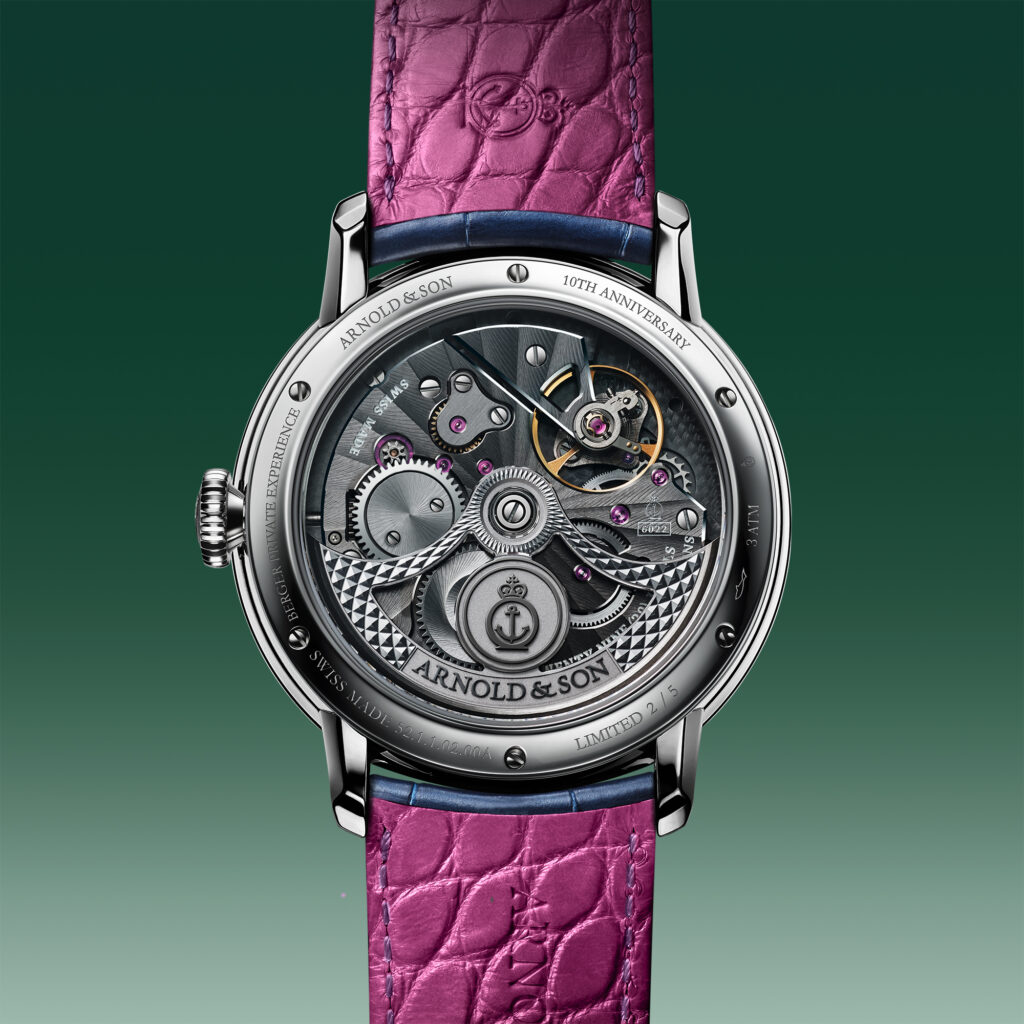 Stacked from 10 images Method=B R=8S=3 - Petróleo y Energía Watch with a transparent case back showing intricate gears, pink leather strap, and stainless steel casing against a green background.