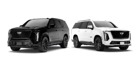 Two Cadillac Escalade SUVs—one black and one white—parked side by side in a neutral setting with large grilles and chrome accents.