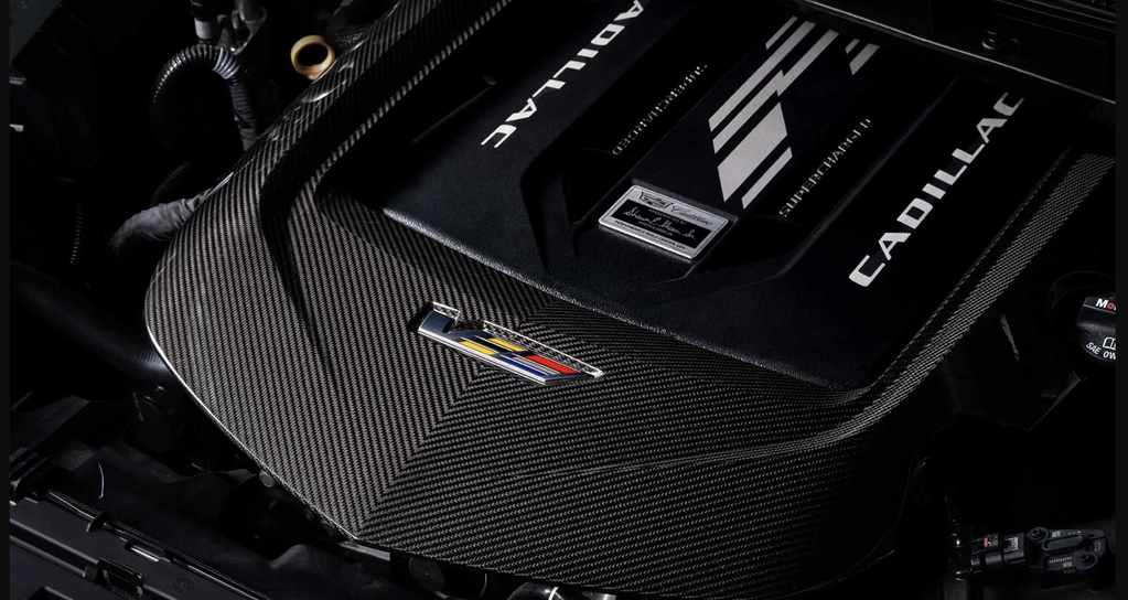 Captura de pantalla 2026-10-23 a las 124816 pm - Petróleo y Energía Close-up of a carbon-fiber car interior with a small multicolor badge and black dashboard accents.