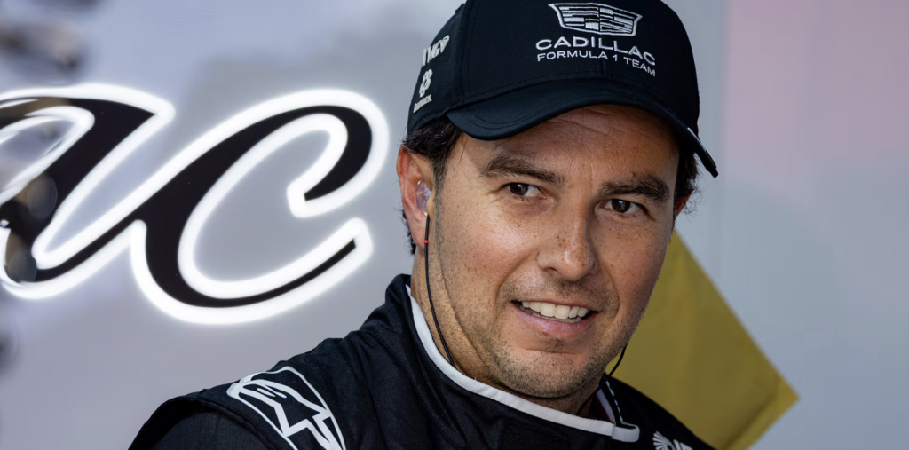 Checo show run 2 - Petróleo y Energía Close-up of a man in a black Cadillac Formula 1 cap, smiling, wearing earphones.