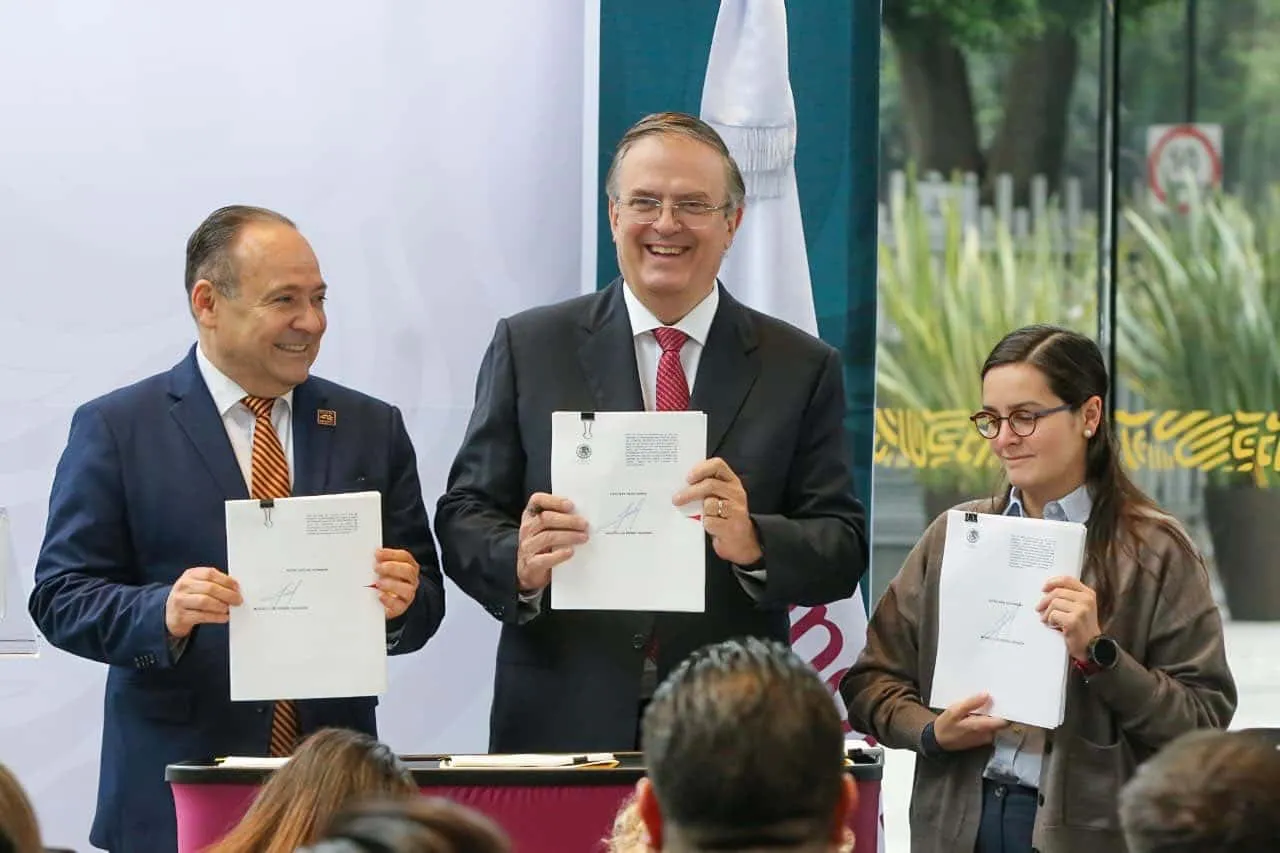 Three professionals in business attire hold signed documents and smile at a signing ceremony.
