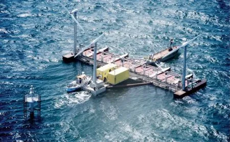 Floating offshore wind turbine installation platform with two turbine nacelles and a yellow equipment module in the open sea