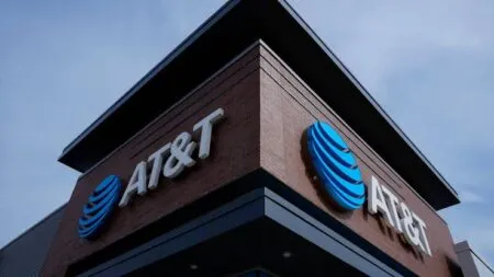 Corner of a brick building featuring AT&T signage with the blue globe logo on the facade.